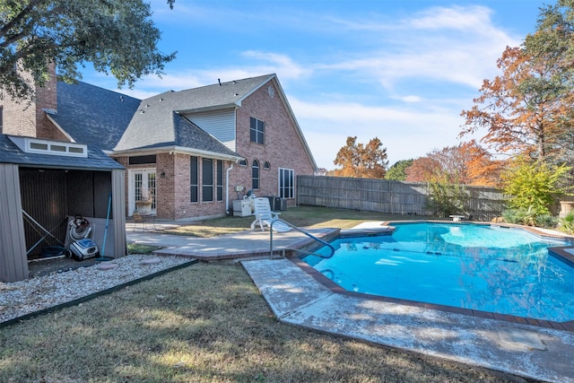 view of pool with a diving board, a yard, and a patio