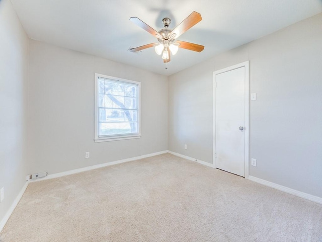 carpeted spare room featuring ceiling fan