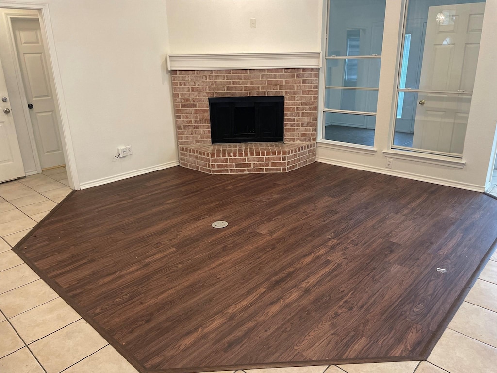 unfurnished living room with built in features, light tile patterned floors, and a fireplace