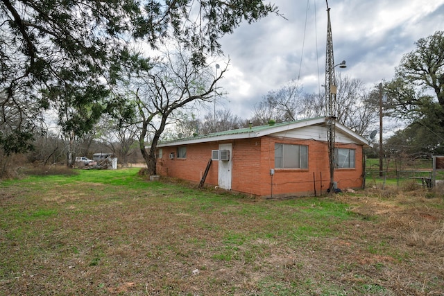 view of home's exterior with a wall unit AC and a yard