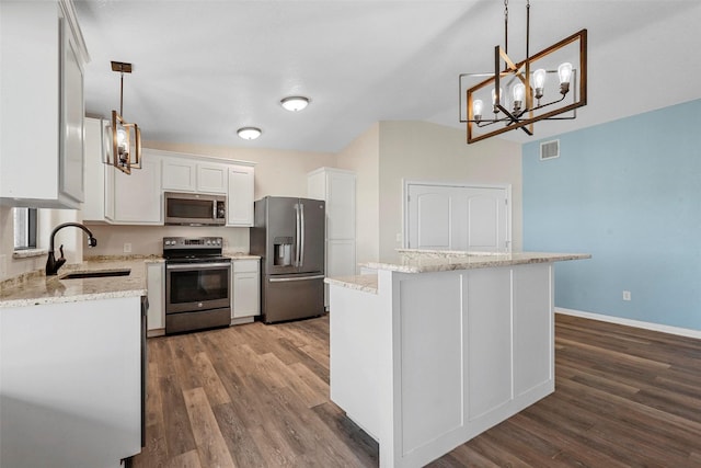 kitchen with white cabinetry, sink, stainless steel appliances, pendant lighting, and a kitchen island