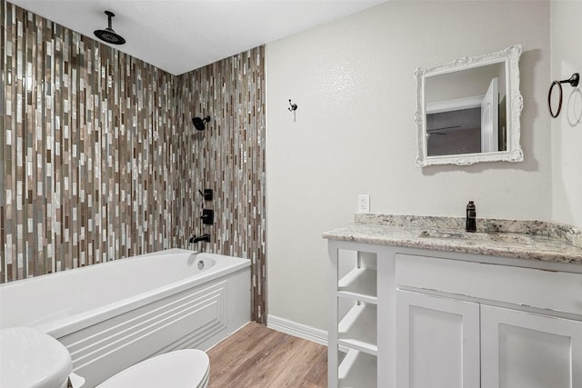 full bathroom with tiled shower / bath, vanity, toilet, and hardwood / wood-style floors