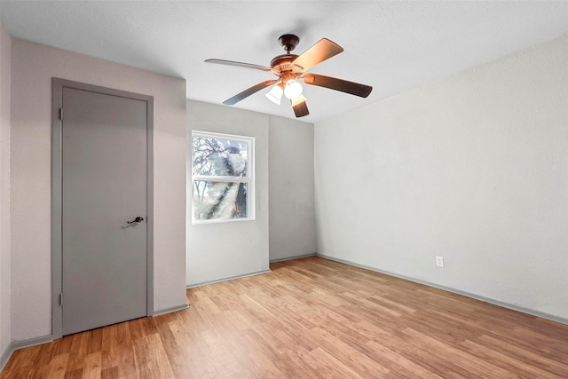 spare room with ceiling fan and light wood-type flooring