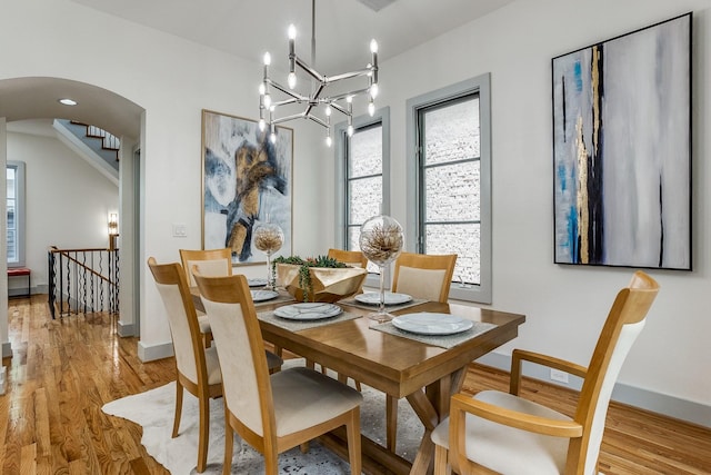 dining space featuring light wood-type flooring and an inviting chandelier