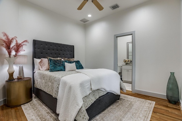 bedroom with ensuite bath, ceiling fan, and light hardwood / wood-style flooring