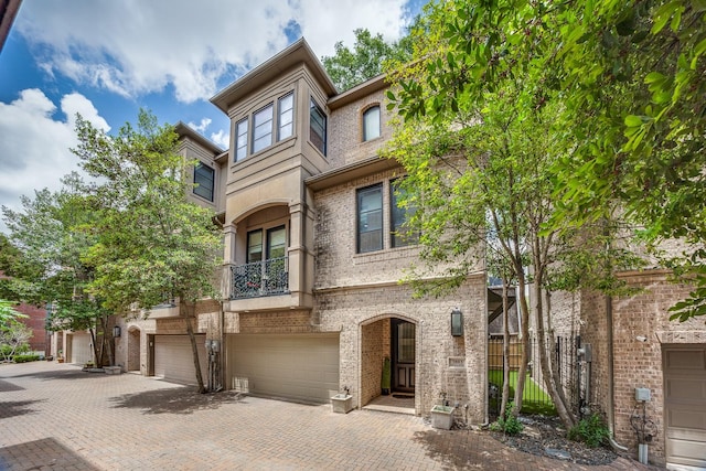 view of property with a balcony and a garage