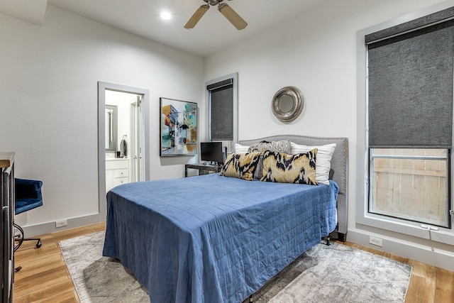 bedroom with connected bathroom, hardwood / wood-style flooring, and ceiling fan