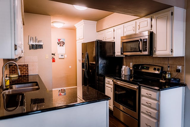 kitchen featuring decorative backsplash, stainless steel appliances, white cabinetry, and sink