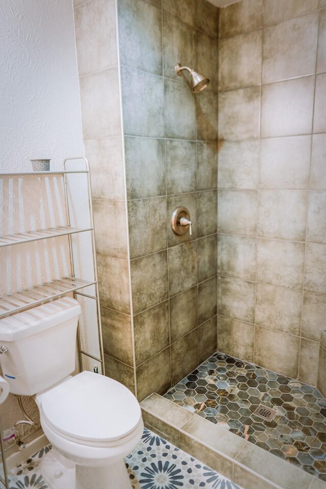 bathroom featuring tile patterned floors, vanity, a shower with shower door, and toilet