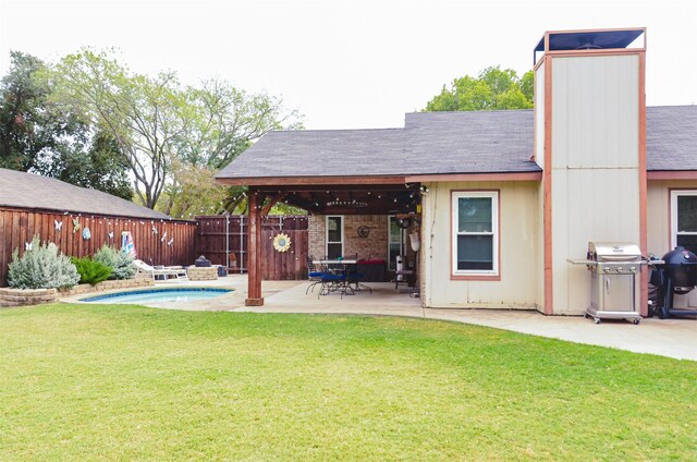 back of property with a yard and a patio