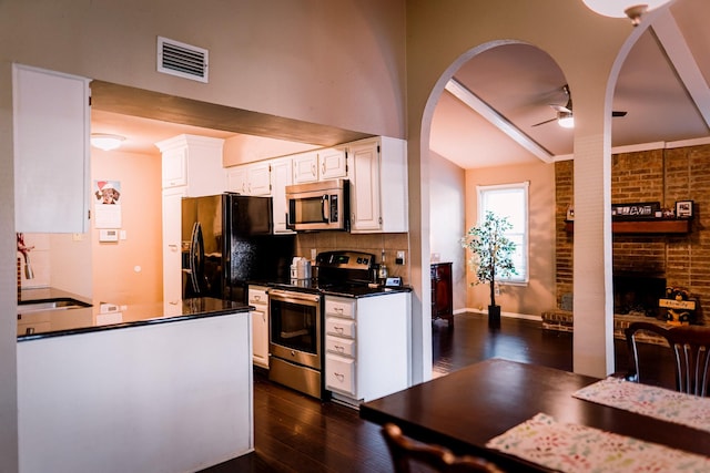 kitchen featuring white cabinetry, sink, ceiling fan, brick wall, and appliances with stainless steel finishes