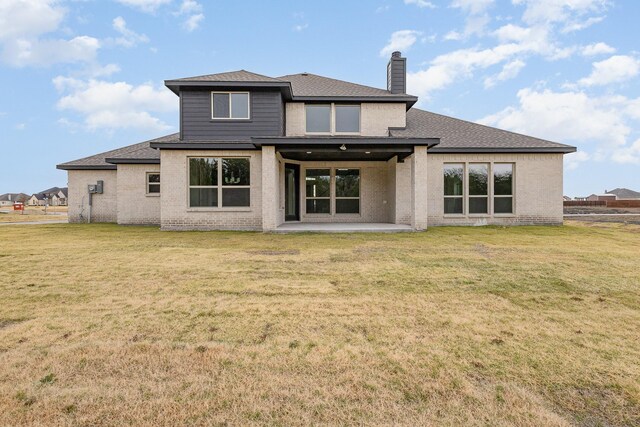 rear view of house featuring a yard and a patio area