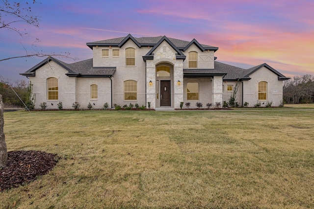 french country inspired facade with a yard