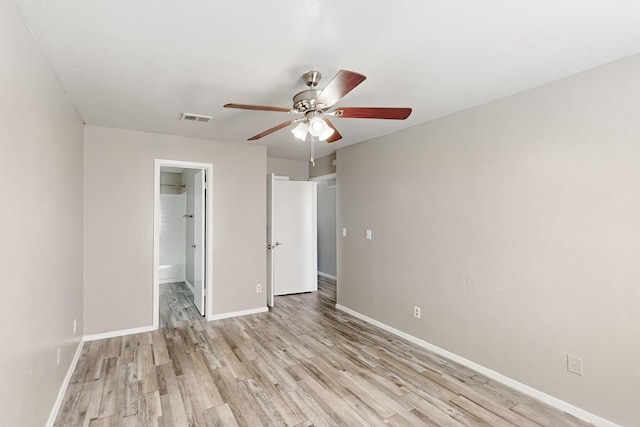 unfurnished bedroom with ceiling fan, connected bathroom, and light wood-type flooring