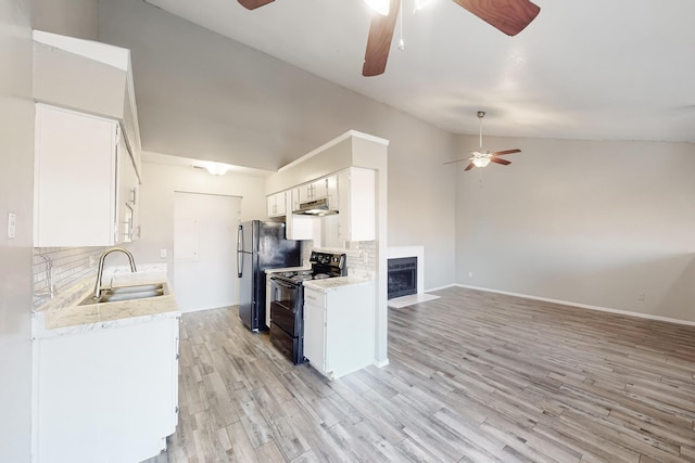 kitchen featuring lofted ceiling, sink, tasteful backsplash, black appliances, and white cabinets