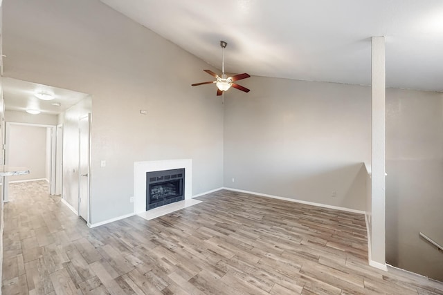 unfurnished living room with ceiling fan, high vaulted ceiling, and light wood-type flooring