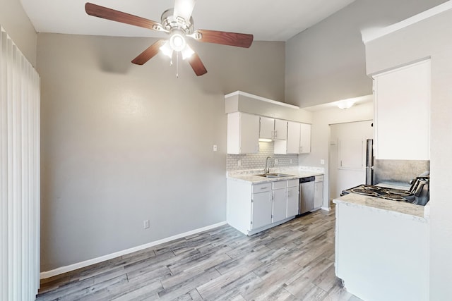 kitchen featuring sink, white cabinets, backsplash, stainless steel dishwasher, and light hardwood / wood-style flooring