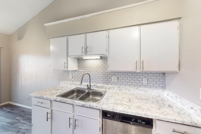 kitchen with vaulted ceiling, tasteful backsplash, white cabinetry, dishwasher, and sink