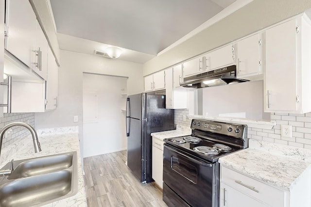 kitchen with tasteful backsplash, sink, white cabinets, black appliances, and light wood-type flooring