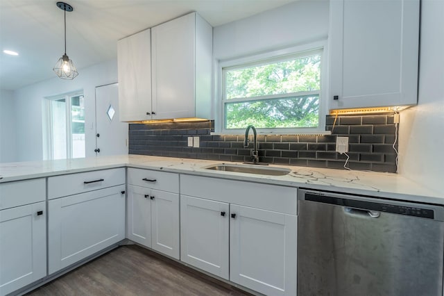 kitchen featuring white cabinets, dark wood finished floors, stainless steel dishwasher, a sink, and tasteful backsplash