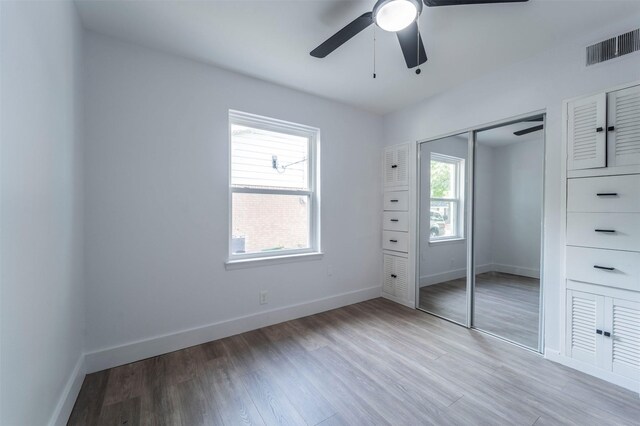 unfurnished bedroom with baseboards, a closet, visible vents, and light wood-style flooring