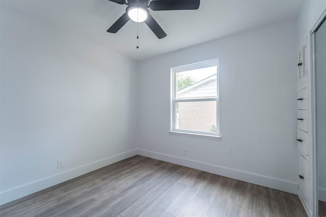 unfurnished room with baseboards, a ceiling fan, and wood finished floors