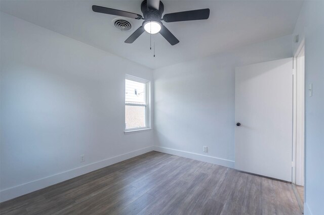 unfurnished room featuring wood finished floors, visible vents, a ceiling fan, and baseboards