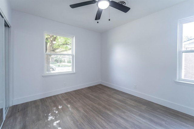 unfurnished room with dark hardwood / wood-style flooring and ceiling fan