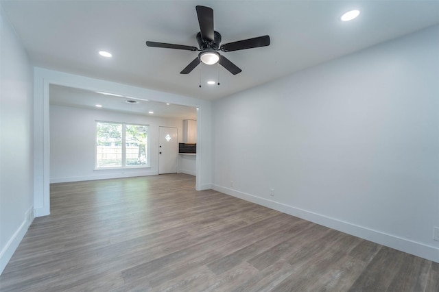 unfurnished living room with wood finished floors, baseboards, recessed lighting, and a ceiling fan