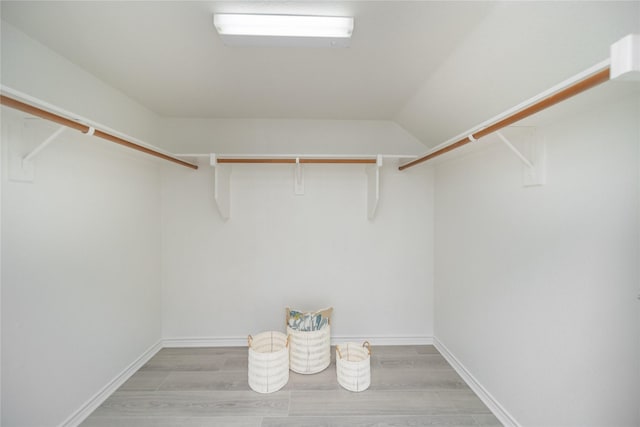 spacious closet with vaulted ceiling and light hardwood / wood-style floors