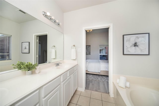 bathroom featuring vanity, a bath, and tile patterned floors