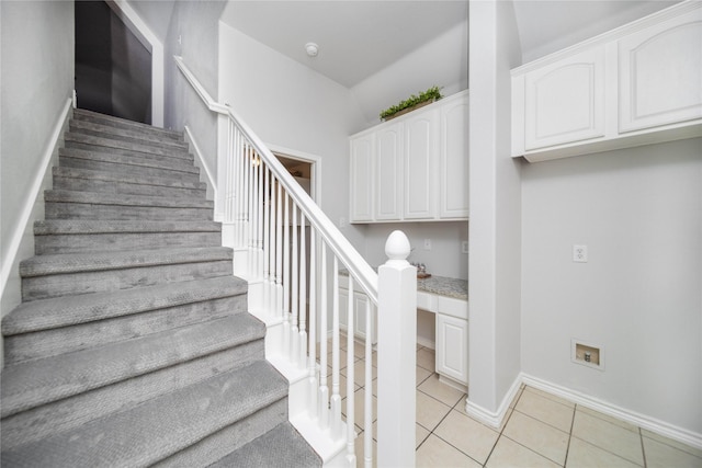 stairs featuring built in desk and tile patterned floors