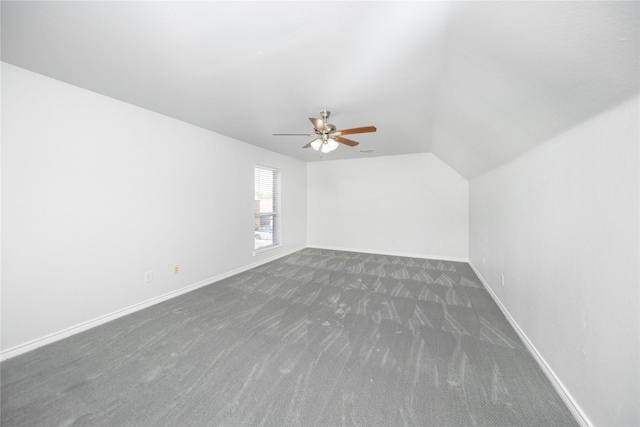 bonus room with dark colored carpet, lofted ceiling, and ceiling fan