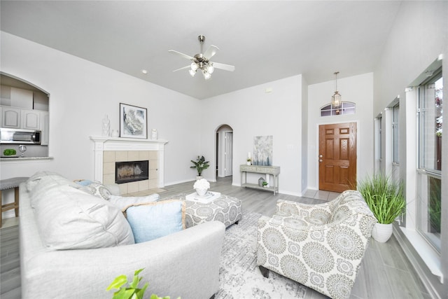 living room with ceiling fan, a fireplace, and light hardwood / wood-style flooring