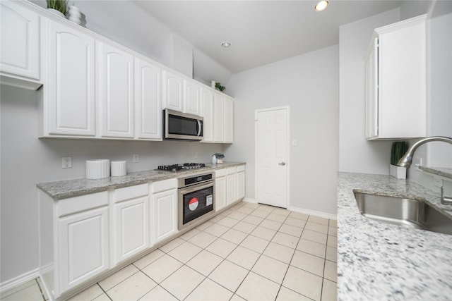 kitchen with white cabinetry, sink, light stone counters, and appliances with stainless steel finishes