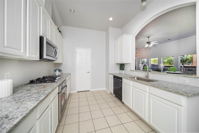 kitchen featuring sink, light stone countertops, white cabinets, and appliances with stainless steel finishes