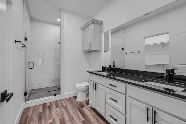 bathroom with vanity, wood-type flooring, a shower with shower door, and toilet