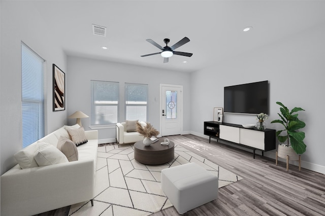 living room featuring ceiling fan and light hardwood / wood-style flooring