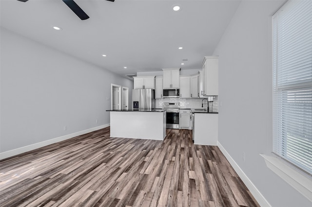 kitchen with white cabinetry, sink, dark hardwood / wood-style floors, backsplash, and appliances with stainless steel finishes