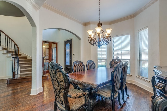 dining space with a notable chandelier, dark hardwood / wood-style flooring, ornamental molding, and french doors