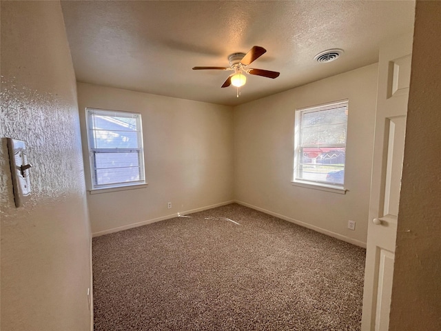 carpeted empty room with ceiling fan and a textured ceiling