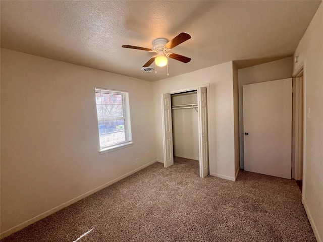 unfurnished bedroom featuring ceiling fan, a closet, carpet, and a textured ceiling