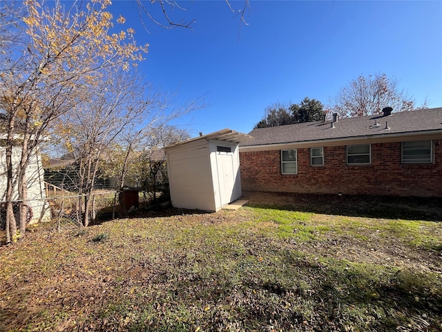 view of side of home with a yard and a storage unit