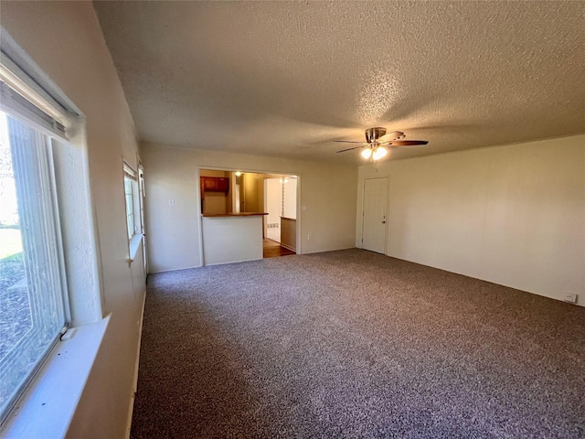 unfurnished living room featuring carpet flooring, ceiling fan, and a textured ceiling