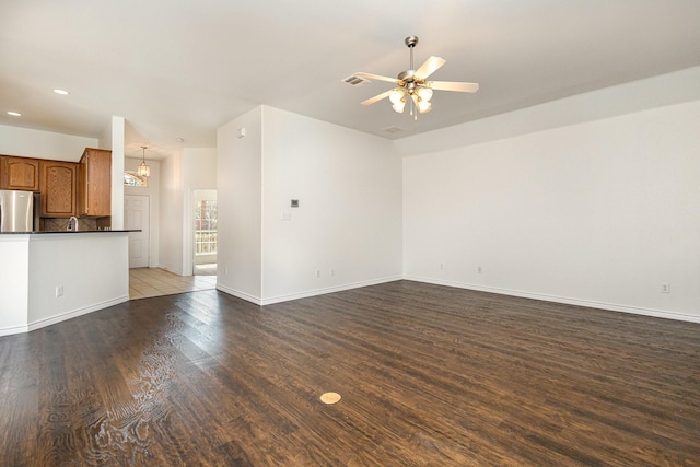 unfurnished living room with dark wood-type flooring and ceiling fan