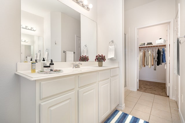 bathroom with walk in shower, tile patterned floors, and vanity