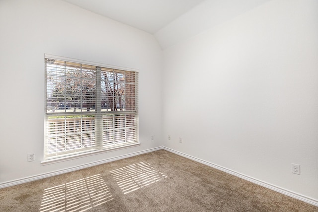 carpeted spare room with lofted ceiling