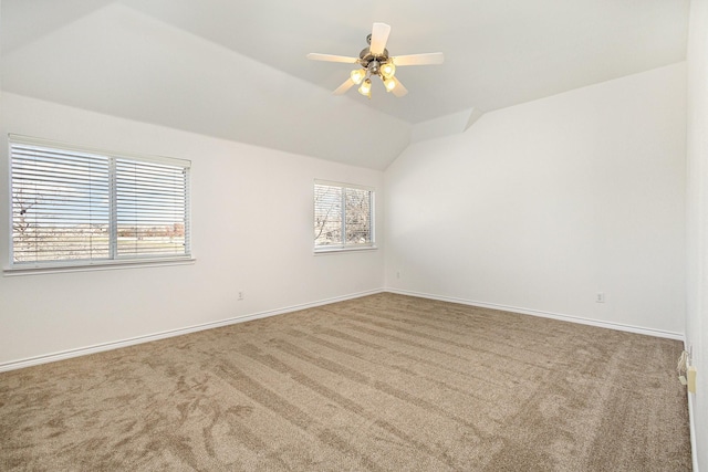 carpeted spare room featuring lofted ceiling, a wealth of natural light, and ceiling fan