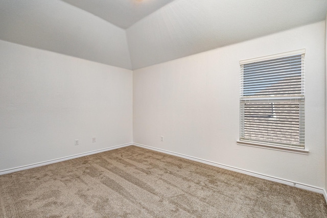 carpeted spare room with lofted ceiling