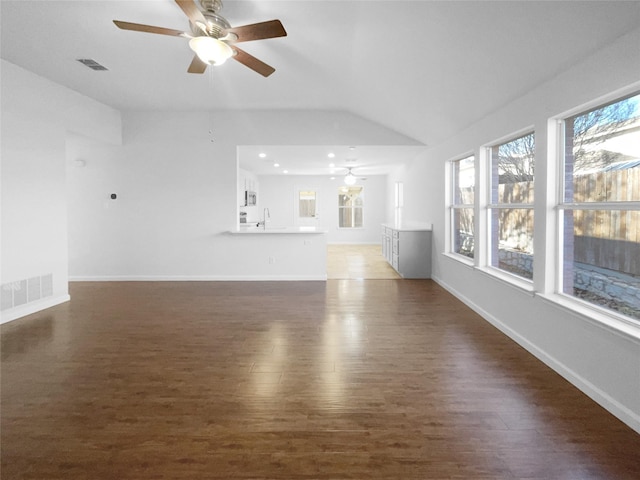 unfurnished living room featuring lofted ceiling, dark wood-type flooring, sink, and ceiling fan